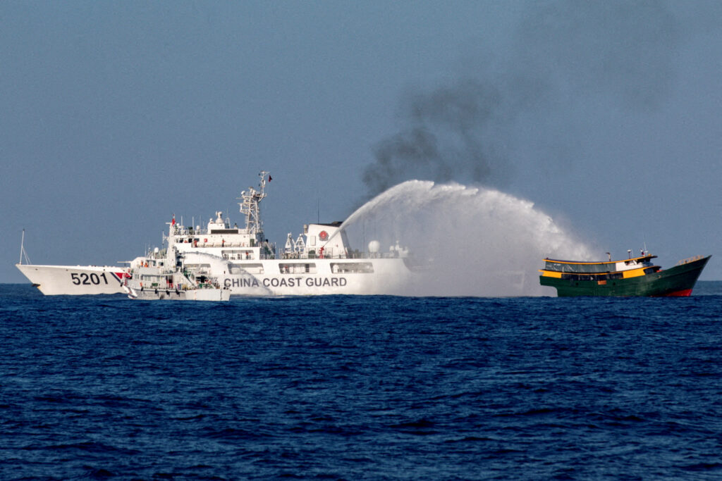 FILE PHOTO: Chinese Coast Guard vessels fire water cannons towards a Philippine resupply vessel Unaizah May 4 as it made its way to the Second Thomas Shoal in the South China Sea